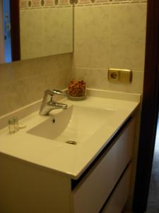 Un baño con un lavabo blanco y un espejo. en Hotel Rodsan Suizo, en Castelldefels
