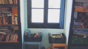 a room with a window and two baskets of books at Refugi Quatre Cases in Clot del Moro +45 photos