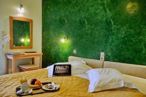 una camera da letto con un letto con una parete verde di Hotel Atlantis a Città di Corfù