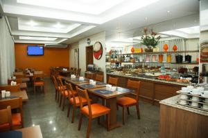 a restaurant with wooden tables and chairs and a buffet at Villalba Hotel in Uberlândia