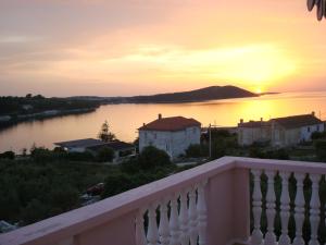 uma vista a partir de uma varanda de um lago ao pôr-do-sol em Guesthouse Villa Ljubica em Soline