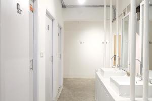 Baño blanco con 2 lavabos y espejo en About A Bed Hostel Chiangmai en Chiang Mai
