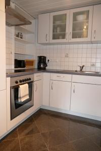 a kitchen with white cabinets and a stove at Ferienwohnung am Markt in Biesenthal