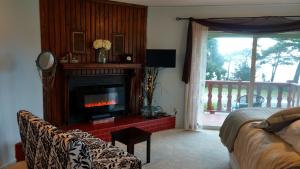 a living room with a fireplace and a couch at Greenhouse Inn by the Bay in Sequim