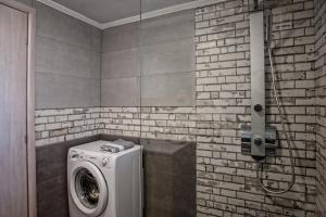 a washer and dryer in a bathroom with a brick wall at Alexandros Villa in Agia Paraskevi