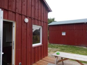 a red barn with a bench next to it at Eiderhufe in Holtsee +11 photos
