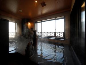 Habitación con bañera llena de agua. en Dormy Inn Hon-Hachinohe en Hachinohe