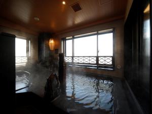 八户市多美迎本八户酒店的一间设有水浴缸的客房