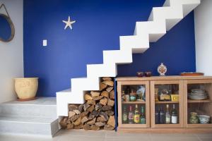 a blue wall with a white staircase next to a shelf of fire wood at Rinconada del Mar in Punta del Este