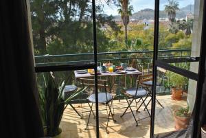a patio with a table and chairs on a balcony at THE BOHO-CHIC OASIS, lovely city center apartment in Málaga