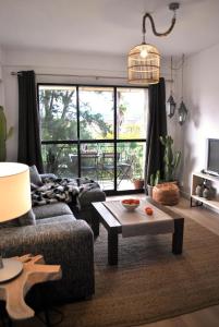 salon z kanapą i stołem w obiekcie THE BOHO-CHIC OASIS, lovely city center apartment w Maladze