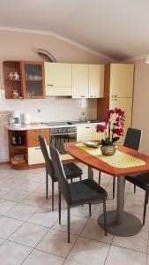 a kitchen with a table with chairs and a table with flowers on it at Rooms & Apartments Giulia in Portorož