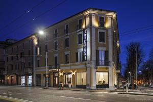 Un gran edificio en una calle de la ciudad por la noche. en Boutique Hotel Liberty 1904, en Bolonia