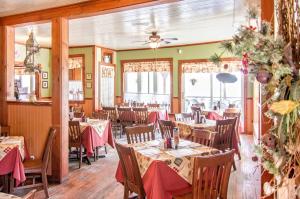 un restaurante con mesas y sillas con servilletas rojas en Auberge Au Soleil Levant, en Piopolis