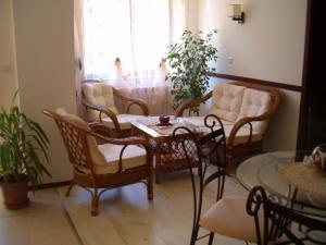 a living room with chairs and a table and a window at Family Hotel Bellehouse in Chernomorets
