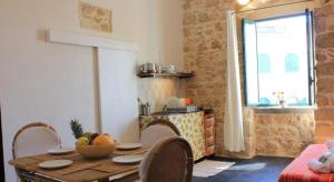 a kitchen with a table with a bowl of fruit on it at Casa Vacanze Magnolia in Punta Secca