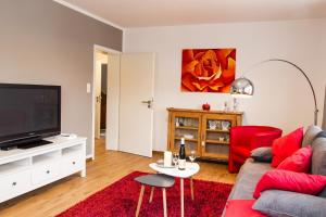 a living room with a red couch and a flat screen tv at Haus Burgfee - Obere Etage in Cochem
