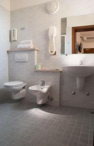 La salle de bains est pourvue de toilettes et d'un lavabo. dans l'établissement Hotel Kennedy, à Caorle