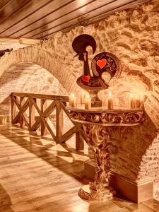 a table with candles and a stone wall at Solar Antigo Luxury Coimbra in Coimbra