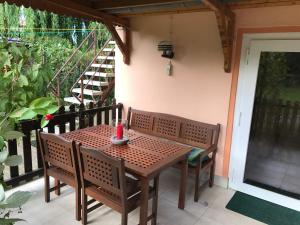 a wooden table and chairs on a balcony with a staircase at Peeneurlaub in Lassan