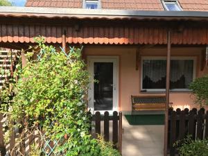 a house with a fence and a bench in front of it at Peeneurlaub in Lassan