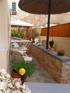 an outdoor patio with chairs and an umbrella at Sweet Home in Karterados