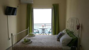 a bedroom with a bed and a balcony with a table at Lighthouse Apartments in Budva