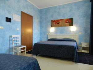 a blue bedroom with two beds and a chair at Hotel Air Palace Lingotto in Turin