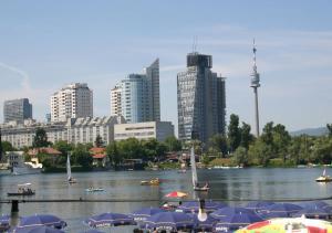 un grupo de barcos en un río con una ciudad en Garden Apartment Donau-City (P&R), en Viena