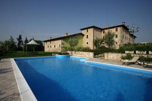 a large blue swimming pool in front of a building at Agriturismo Macesina in bedizzol