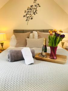 a bed with a tray of flowers and a bottle of champagne at The Celyn in Pont Newydd
