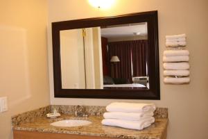 La salle de bains est pourvue d'un lavabo, d'un miroir et de serviettes. dans l'établissement Saxony Motel, à Chatham