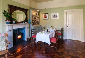 a dining room with a table and a fireplace at Ravenhill House in Belfast