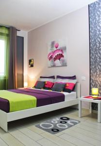 Un dormitorio con una cama con morado y verde. en Blau Vacanze, en Peschiera del Garda