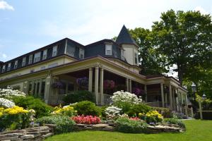 a house with a large garden and a clock on the front of it at Stafford's Bay View Inn in Petoskey
