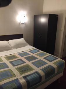 Un dormitorio con una cama y un armario negro. en Hotel Chevallier, en Levallois-Perret