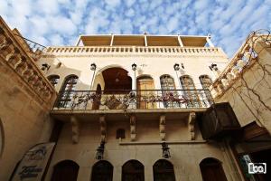 - un bâtiment avec un balcon fleuri dans l'établissement Turkmen Konagi, à Şanlıurfa