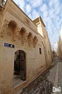 a building with a sign on the side of it at Turkmen Konagi in Sanlıurfa