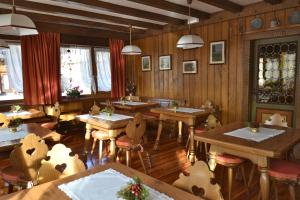 una sala da pranzo con tavoli e sedie in legno di Hotel Villa Nevada a Cortina dʼAmpezzo