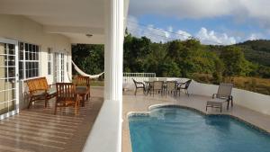 a patio with a table and chairs and a swimming pool at Villa Sans Souci in Vieux Fort