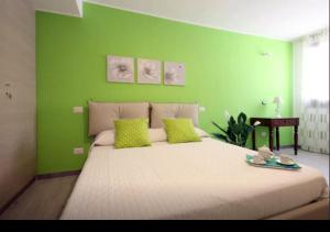 a bedroom with a large bed with a green wall at Rainbow in Castellammare del Golfo