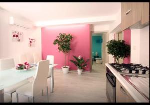 a kitchen with pink walls and a table and chairs at Rainbow in Castellammare del Golfo