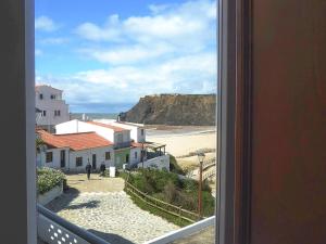 a view of a beach from a window at Ponta Branca Beach House in Odeceixe