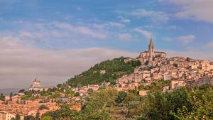 a town on top of a hill with a church at Locanda del Borgo in Todi