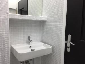 ein weißes Badezimmer mit Waschbecken und Spiegel in der Unterkunft new design apartment in Duisburg + 15 Fotos