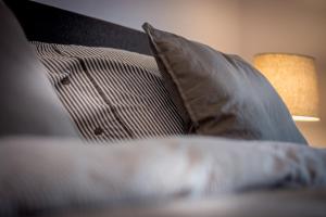 - une pile d'oreillers sur un lit avec une lampe dans l'établissement Guesthouse 115, à Fauquemont