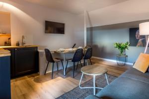 a kitchen and a living room with a table and chairs at Guesthouse 115 in Valkenburg
