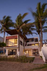 a house with palm trees in front of it at Casita de la Playa in Puerto Villamil