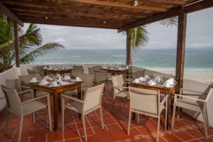 un restaurante en la playa con mesas y sillas en Casita de la Playa, en Puerto Villamil