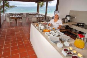 a woman in a kitchen preparing food in a restaurant at Casita de la Playa in Puerto Villamil